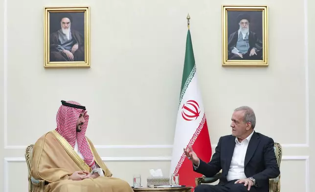 In this photo released by the Iranian Presidency Office, President Masoud Pezeshkian, right, speaks with Saudi Arabia's Defense Minister Prince Khalid bin Salman during their meeting, in Tehran, Iran, Thursday, April 17, 2025. (Iranian Presidency Office via AP)
