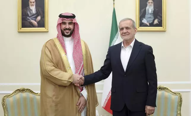 In this photo released by the Iranian Presidency Office, President Masoud Pezeshkian, right, shakes hands with Saudi Arabia's Defense Minister Prince Khalid bin Salman at the start of their meeting, in Tehran, Iran, Thursday, April 17, 2025. (Iranian Presidency Office via AP)