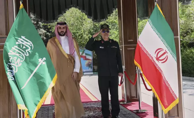 This image released by the public relations of the General Staff of Iran's Armed Forces, Saudi Arabia's Defense Minister Prince Khalid bin Salman, left, and Chief of the General Staff of Iran's Armed Forces Gen. Mohammad Hossein Bagheri listen to their countries national anthem during a welcoming ceremony for Prince Khalid bin Salman, in Tehran, Thursday, April 17, 2025. (Public relation of the General Staff of Iran's Armed Forces via AP)