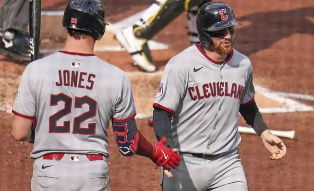 Cleveland Guardians' Daniel Schneemann, right, greeted by Nolan Jones after scoring on a single by Steven Kwan off Pittsburgh Pirates pitcher Paul Skenes during the third inning of a baseball game in Pittsburgh, Saturday, April 19, 2025. (AP Photo/Gene J. Puskar)