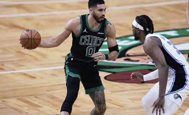 Boston Celtics forward Jayson Tatum (0) drives to the basket against Orlando Magic center Wendell Carter Jr. (34) during the first half in Game 5 of a first-round NBA playoff basketball series, Tuesday, April 29, 2025, in Boston. (AP Photo/Charles Krupa)