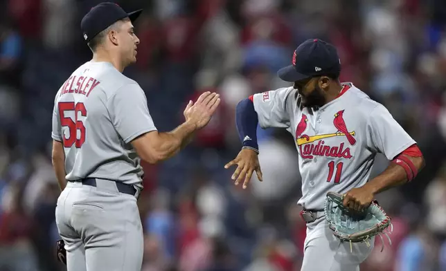 St. Louis Cardinals' Ryan Helsley, left, and Victor Scott II celebrate after the Cardinals won a baseball game against the Philadelphia Phillies Monday, May 12, 2025, in Philadelphia. (AP Photo/Matt Slocum)