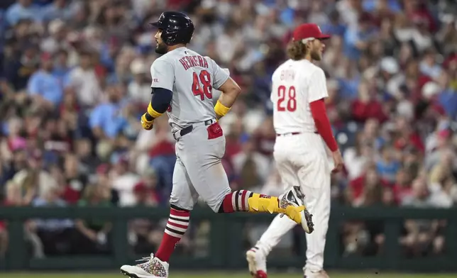 St. Louis Cardinals' Iván Herrera, left, rounds the bases past Philadelphia Phillies third baseman Alec Bohm after hitting a home run against pitcher Cristopher Sánchez during the sixth inning of a baseball game Monday, May 12, 2025, in Philadelphia. (AP Photo/Matt Slocum)