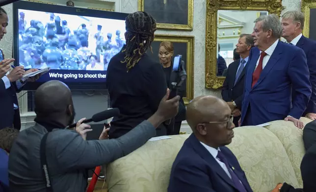 South African businessman Johann Rupert, standing right, watches a video during a meeting between President Donald Trump and South African President Cyril Ramaphosa in the Oval Office of the White House, Wednesday, May 21, 2025, in Washington. (AP Photo/Evan Vucci)
