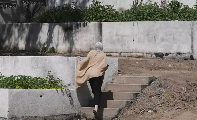 Kathryn Frazier visits her fire-damaged property, which she plans to rebuild, in Altadena, Calif., on Tuesday, April 22, 2025. (AP Photo/Damian Dovarganes)