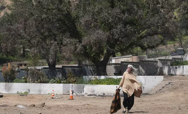 Kathryn Frazier visits her fire-damaged property, which she plans to rebuild, in Altadena, Calif., on Tuesday, April 22, 2025. (AP Photo/Damian Dovarganes)