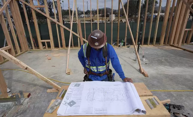 Contractors rebuild a home destroyed by the Palisades Fire in the Pacific Palisades neighborhood of Los Angeles, on Thursday, April 24, 2025. (AP Photo/Damian Dovarganes)