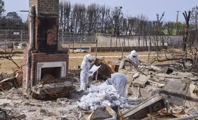 Cal/OSHA workers remove hazardous materials from a home destroyed by the Palisades Fire in the Pacific Palisades neighborhood of Los Angeles, Thursday, April 24, 2025. (AP Photo/Damian Dovarganes)