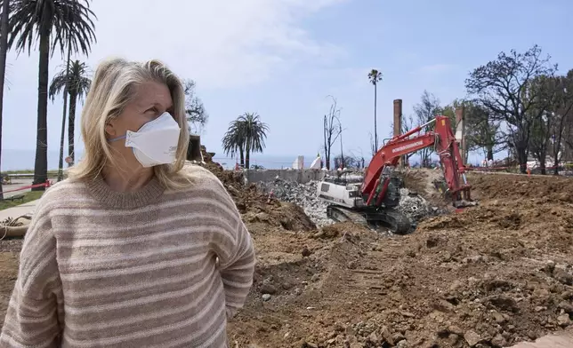 Pacific Palisades property owner DeAnn Heline stands in front of her home being rebuilt after the Palisades Fire in the Pacific Palisades section of Los Angeles, Thursday, April 24, 2025. (AP Photo/Damian Dovarganes)