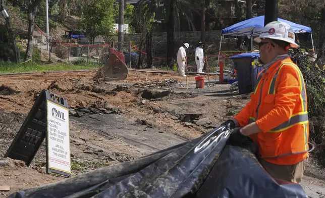 Crews remove debris from a home destroyed by the Eaton Fire in Altadena, Calif., on Tuesday, April 22, 2025. (AP Photo/Damian Dovarganes