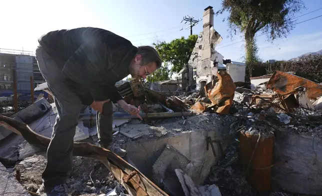 Tim Vordtriede looks through the remains of his property, which was destroyed by the Eaton Fire in Altadena, Calif., on Tuesday, April 22, 2025. (AP Photo/Damian Dovarganes)