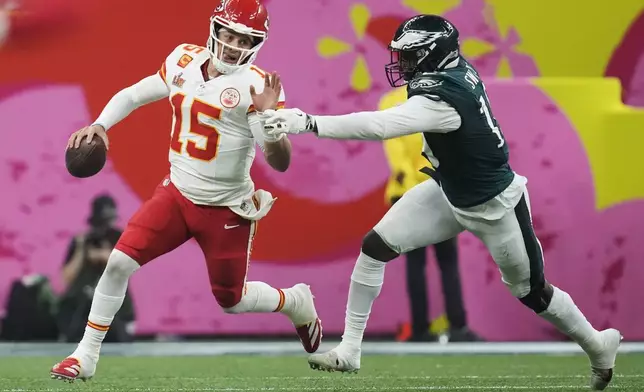 FILE - Kansas City Chiefs quarterback Patrick Mahomes (15) eludes the reach of Philadelphia Eagles linebacker Josh Sweat during the second half of the NFL Super Bowl 59 football game on Feb. 9, 2025, in New Orleans. (AP Photo/Ashley Landis, File)