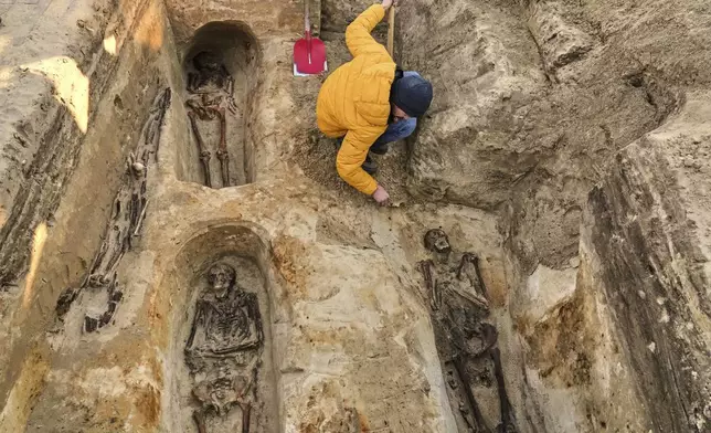 A worker of the German War Graves Commission works on the exhumation of remains of German WWII soldiers in Ostrołęka, Poland, Wednesday, March 19, 2025. (AP Photo/Czarek Sokolowski)