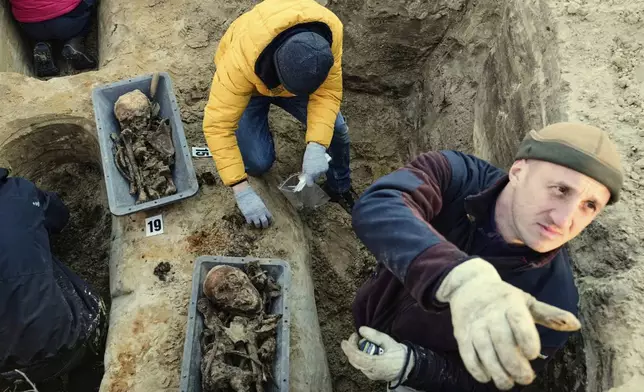 Workers of the German War Graves Commission exhume the remains of German WWII soldiers in Ostrołęka, Poland, Wednesday, March 19, 2025. (AP Photo/Czarek Sokolowski)