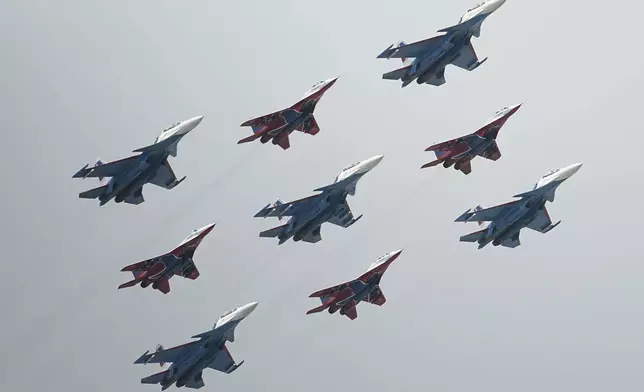 CORRECTS JETS MODIFICATION - Russian Sukhoi Su-30SM jet fighters, centre, of The Russian Knights aerobatic team and Mikoyan MiG-29 jet fighters of The Swifts aerobatic team fly over the Red Square during the Victory Day parade rehearsal in Moscow, Russia, Monday, May 5, 2025. (AP Photo/Pavel Bednyakov)