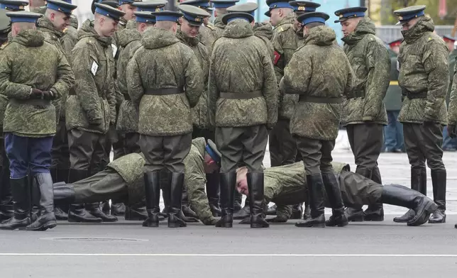 Russian army servicemen compete in push-ups to warm in the cold weather prior to a rehearsal for the Victory Day military parade at the Dvortsovaya (Palace) Square in St. Petersburg, Russia, Monday, May 5, 2025. (AP Photo/Dmitri Lovetsky)