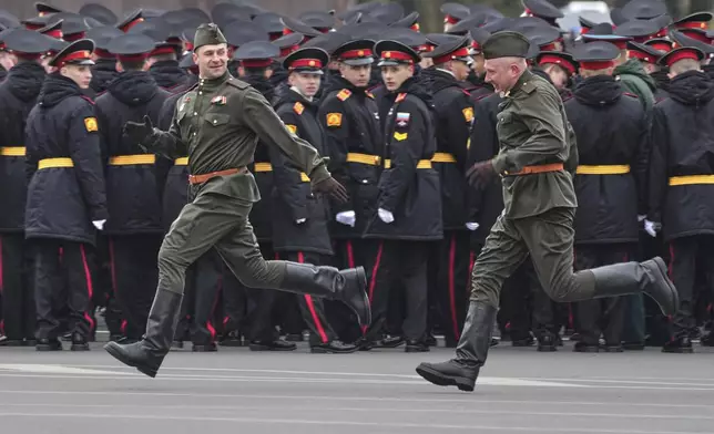 Russian army servicemen wearing Soviet army uniform run to warm up in the cold weather prior to a rehearsal for the Victory Day military parade at the Dvortsovaya (Palace) Square in St. Petersburg, Russia, Monday, May 5, 2025. (AP Photo/Dmitri Lovetsky)