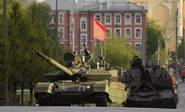 A Russian tank and a self-propelled howitzer roll along a street toward Red Square to attend a rehearsal for the Victory Day military parade in Moscow, Russia, on Tuesday, April 29, 2025. (AP Photo/Alexander Zemlianichenko)