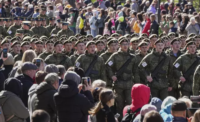People look at Russian army soldiers marching to attend a rehearsal for the Victory Day military parade at the Dvortsovaya (Palace) Square in St. Petersburg, Russia, Saturday, May 3, 2025. (AP Photo/Dmitri Lovetsky)