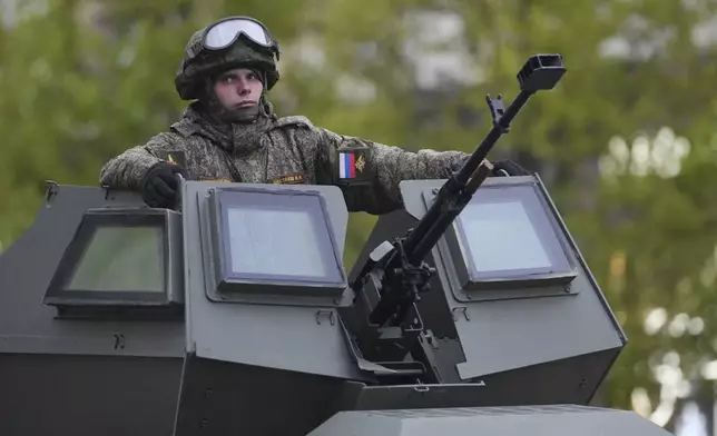 A Russian soldiers sits atop his military vehicle driving along Tverskaya street to attend a rehearsal for the Victory Day military parade in Moscow, Russia, on Tuesday, April 29, 2025. (AP Photo/Pavel Bednyakov)