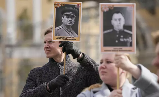 An actor holds a portrait of Soviet leader Joseph Stalin, left, as he marches with other actors holding portraits of Soviet military leaders during a rehearsal for the Victory Day military parade at the Dvortsovaya (Palace) Square in St. Petersburg, Russia, Wednesday, April 30, 2025. (AP Photo/Dmitri Lovetsky)
