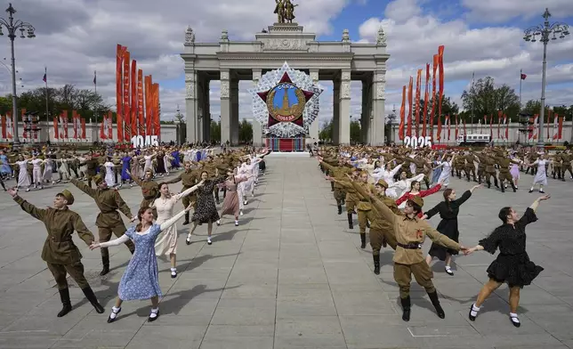 Moscow students dressed in the fashion of the middle of the last century and Soviet style uniform perform "Victory Waltz" as a part of Victory Day celebration in front of the a model of the main Soviet order, the Order of Victory at the historical gate of VDNKh, The Exhibition of Achievements of National Economy in Moscow, Russia, Tuesday, May 6, 2025. (AP Photo/Alexander Zemlianichenko)
