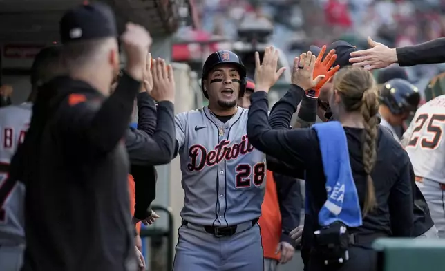 Detroit Tigers' Javier Baez (28) high-fives teammates in the dugout after hitting a home run during the third inning of a baseball game against the Los Angeles Angels, Thursday, May 1, 2025, in Anaheim, Calif. (AP Photo/Eric Thayer)