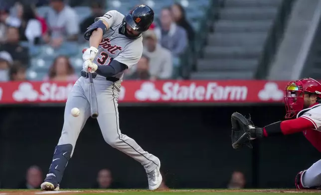 Detroit Tigers' Riley Greene, left, makes contact with the ball during the first inning of a baseball game against the Los Angeles Angels, Thursday, May 1, 2025, in Anaheim, Calif. (AP Photo/Eric Thayer)