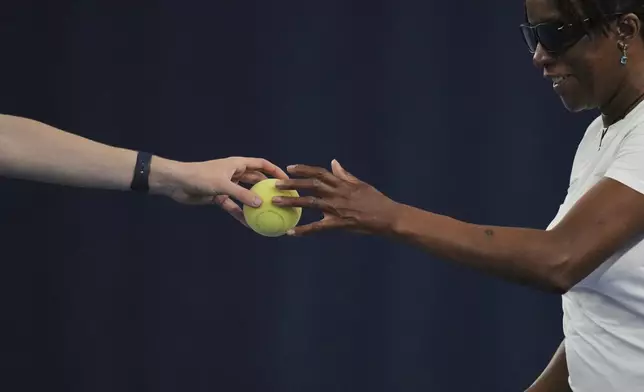 Marvel Opara, who is partially sighted, reaches out to take a ball as she attends a visually impaired tennis training session in London, Wednesday, May 14, 2025. (AP Photo/Kin Cheung)