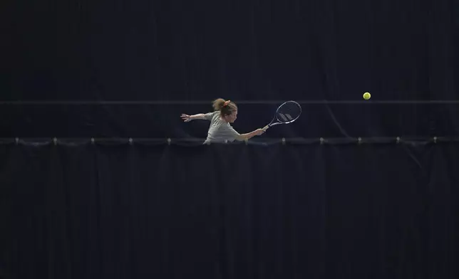 Odette Battarel, who is partially sighted, plays a shot during a visually impaired tennis training session in London, Wednesday, May 14, 2025. (AP Photo/Kin Cheung)