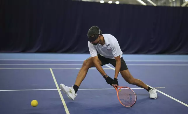 Blind tennis champion Naqi Rizvi plays a shot during a visually impaired tennis training session in London, Tuesday, May 20, 2025. (AP Photo/Kin Cheung)
