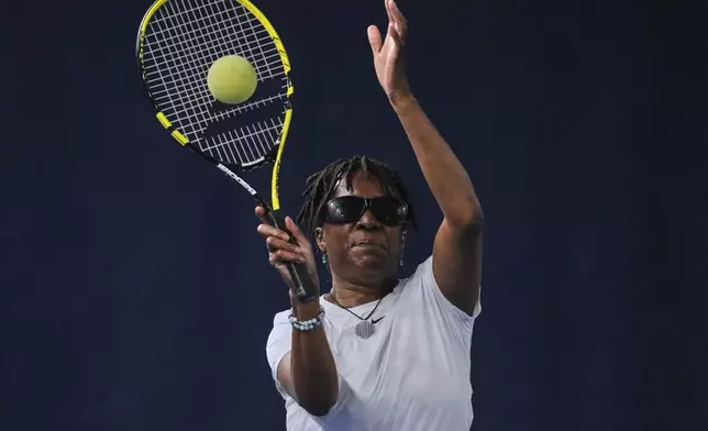 Marvel Opara, who is partially sighted, serves the ball during a visually impaired tennis training session in London, Wednesday, May 14, 2025. (AP Photo/Kin Cheung)