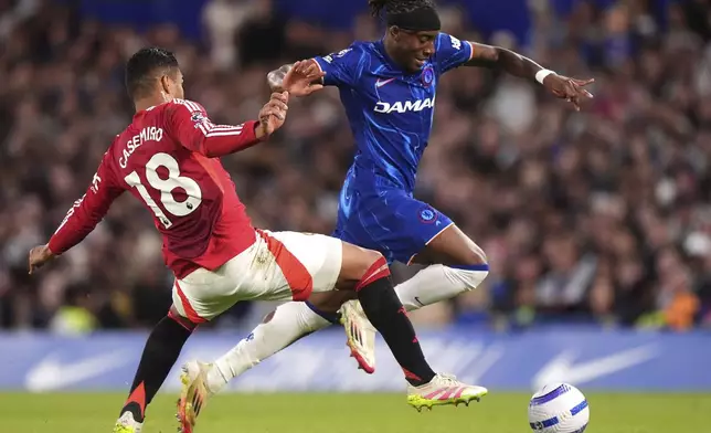 Manchester United's Casemiro, left, challenges Chelsea's Noni Madueke during the English Premier League soccer match between Chelsea and Manchester United at Stamford Bridge, London, Friday, May 16, 2025. (Bradley Collyer/PA via AP)