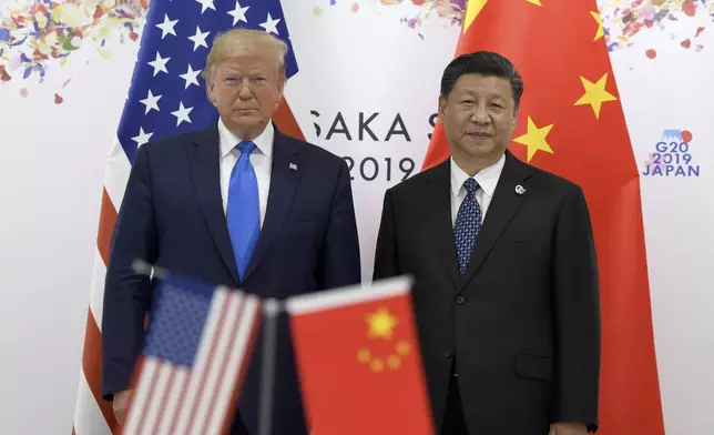 FILE - President Donald Trump, left, poses for a photo with Chinese President Xi Jinping during a meeting on the sidelines of the G-20 summit in Osaka, Japan, June 29, 2019. (AP Photo/Susan Walsh, File)