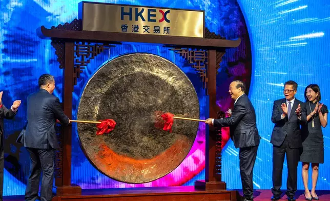 Robin Zeng, chairman of Contemporary Amperex Technology Co. (CATL), center right, strikes the gong at the listing ceremony in Hong Kong, Tuesday, May. 20, 2025. (AP Photo/Chan Long Hei)