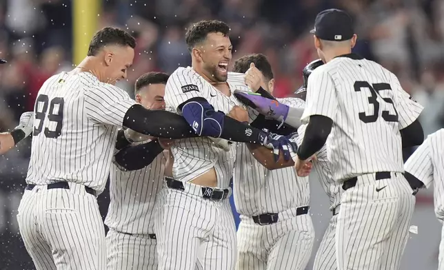 New York Yankees' J.C. Escarra, center, celebrates with teammates after hitting a walk-off sacrifice fly ball during the 10th inning of a baseball game against the San Diego Padres Wednesday, May 7, 2025, in New York. (AP Photo/Frank Franklin II)