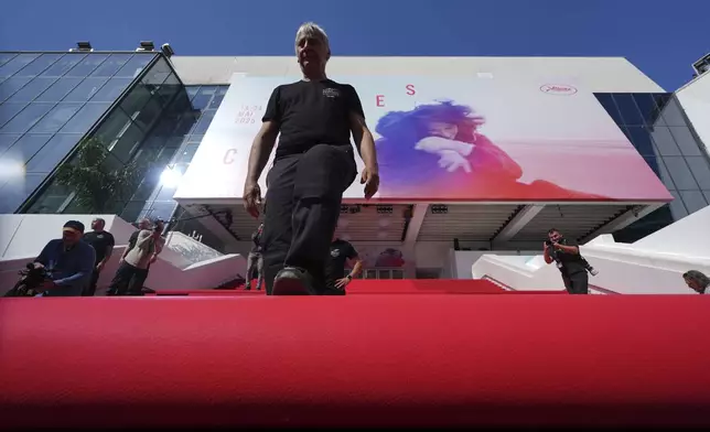 Crew members install the red carpet at the Palais des Festivals ahead of the opening ceremony of the 78th international film festival, Cannes, southern France, Tuesday, May 13, 2025. (AP Photo/Natacha Pisarenko)