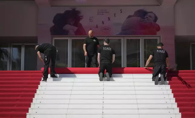 Crew members install the red carpet at the Palais des Festivals ahead of the opening ceremony of the 78th international film festival, Cannes, southern France, Tuesday, May 13, 2025. (Photo by Lewis Joly/Invision/AP)