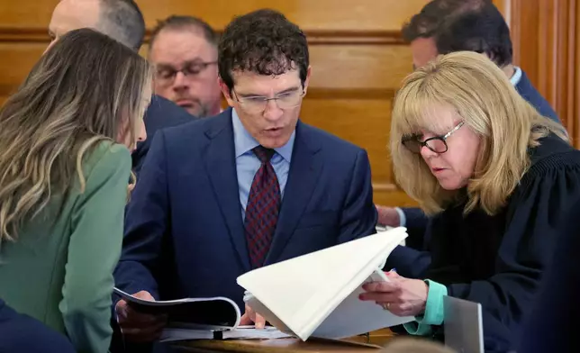 Defense attorney Robert Alessi, center, confers with Superior Court Judge Beverly Cannone as Karen Read, left, stands by during a sidebar during Read's murder trial at Norfolk Superior Court, Tuesday, May 27, 2025, in Dedham, Mass. (Matt Stone/The Boston Herald via AP, Pool)
