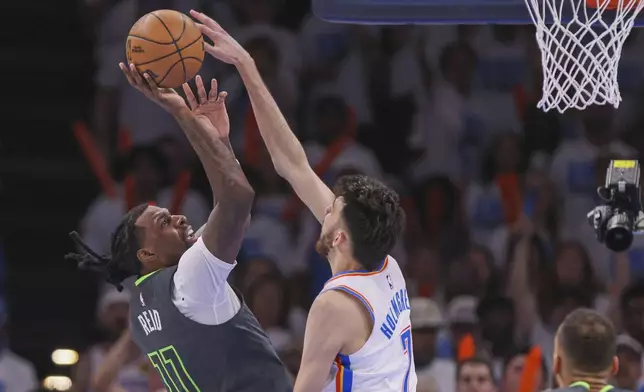 Oklahoma City Thunder forward Chet Holmgren, right, attempts a block on a shot by Minnesota Timberwolves center Naz Reid (11) during the second half of Game 1 of an NBA basketball Western Conference Finals playoff series Tuesday, May 20, 2025, in Oklahoma City. (AP Photo/Nate Billings)