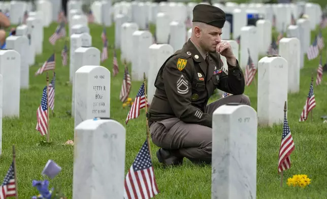 FILE - A member of the Army visits Section 60 of Arlington National Cemetery, in Arlington, Va., Monday, May 27, 2024, on Memorial Day. (AP Photo/Jacquelyn Martin, File)