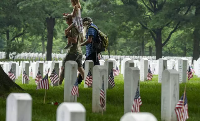 FILE - Families visit Section 60 of Arlington National Cemetery, in Arlington, Va., Monday, May 27, 2024, in honor of Memorial Day. (AP Photo/Jacquelyn Martin, File)