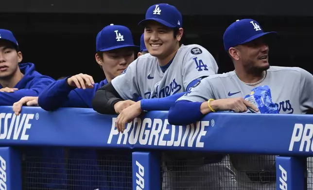 Los Angeles Dodgers' Shohei Ohtani smiles in the dugout during the first inning of a baseball game against the Cleveland Guardians, Tuesday, May 27, 2025, in Cleveland. (AP Photo/David Dermer)