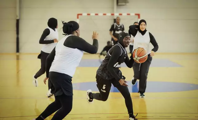 A player wearing a headscarf warms-up before a basketball game in Aubervilliers near Paris, Sunday, April 27, 2025. (AP Photo/Thomas Padilla)