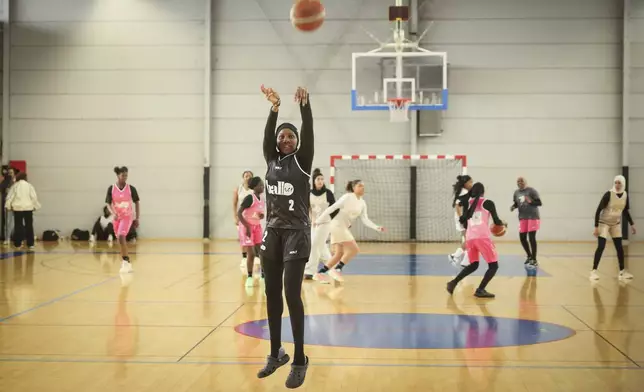 A player wearing a headscarf warmup before a competition, in Aubervilliers near Paris, Sunday, April 27, 2025. (AP Photo/Thomas Padilla)
