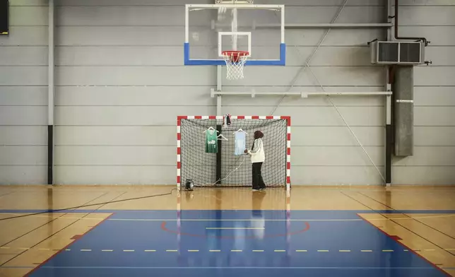 Former player Salimata Sylla prepares the players' jerseys before a women's basketball tournament where players can wear a headscarf, in Aubervilliers near Paris, Sunday, April 27, 2025. (AP Photo/Thomas Padilla)