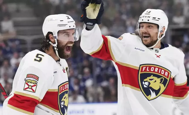 Florida Panthers' Aaron Ekblad (5) celebrates his goal against the Toronto Maple Leafs with Sam Reinhart (13) during first period NHL playoff hockey action in Toronto on Wednesday, May 14, 2025. (Nathan Denette/The Canadian Press via AP)