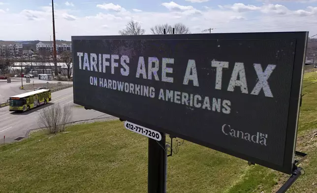 FILE - A digital bill board flashes a tariffs message in Kennedy Township, Pa., Tuesday, March 25, 2025. (AP Photo/Gene J. Puskar, file)
