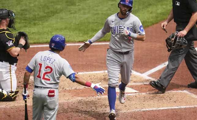 Chicago Cubs' Dansby Swanson (7) is greeted by Nicky Lopez (12) as he heads to the dugout after hitting a solo home run off Pittsburgh Pirates pitcher Paul Skenes during the fifth inning of a baseball game in Pittsburgh, Thursday, May 1, 2025. (AP Photo/Gene J. Puskar)