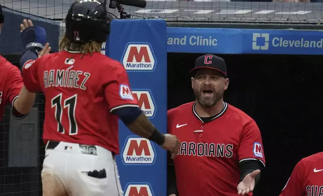 Cleveland Guardians manager Stephen Vogt, right, greets Jose Ramirez (11) as he returns to the dugout after scoring in the sixth inning of a baseball game against the Milwaukee Brewers in Cleveland, Monday, May 12, 2025. (AP Photo/Sue Ogrocki)